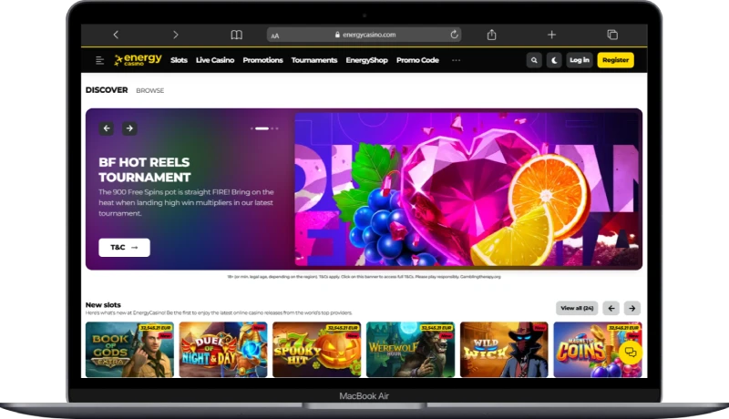 Laptop screen showing the Energy Casino homepage with slot games and welcome promotions for new players